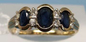 A 9ct gold ring set with three oval sapphires and alternating diamonds (size N)