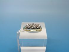 An 18ct gold ring set with three diamonds, the centre diamond measuring approx 0.