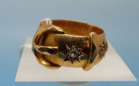 A hallmarked 18ct gold buckle ring set with two diamonds in star settings (size N, 7.