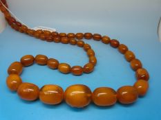 A large amber necklace of graduating oval beads, the largest approximately 2.