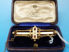 A hallmarked 15ct gold brooch set with rubies and a diamond in original box (4.