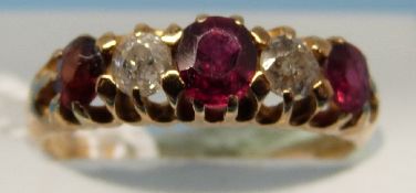 A yellow metal ring set with alternating garnets and diamonds (size H)