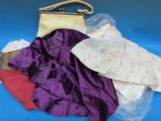 A collection of vintage textiles to include lace, dresses, children's clothing,