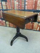 A mahogany drop leaf side table raised on a tripod base,