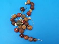 A Chinese beaded necklace of 29 carved cinnabar lacquer,