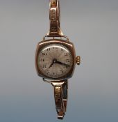 A gold circa 1920s ladies' Rolex watch with Arabic numerals on an engineered silver dial and on