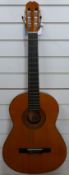 A Ronda Spanish acoustic six string guitar with a melodica,
