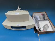 A Bose Wave music system with remote and original paperwork.