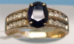 A 9ct gold ring set with an oval sapphire and two rows of diamonds to each shoulder (size P)