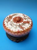 A 19th century hand decorated Japanese bowl and cover on stand,