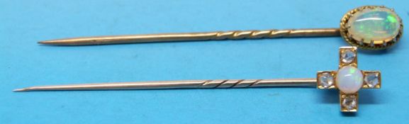 Two yellow metal stick pins one set with an opal and four diamonds in a cross shape and the other