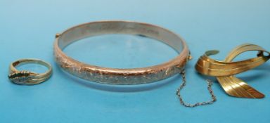 A hallmarked 9ct gold bangle with floral decoration,