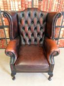 A red leather Chesterfield wing back armchair