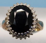 An 9ct gold ring set with a large oval sapphire surrounded by diamonds (size N)
PLEASE NOTE THIS IS