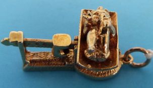 A 9ct gold charm in the form of a baby on scales with articulated mechanism and slide weight,