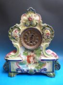 A ceramic-cased late 19th century mantel clock with embossed gilt dial