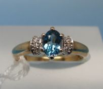 A 9ct gold ring set with a blue topaz and diamonds (size J)