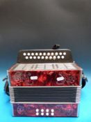 A two row German melodeon in keys GD in red pearloid finish,
