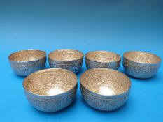 Six Indian white metal (tests as silver) rice bowls with all-over repoussé decoration including