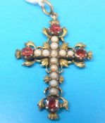 A cross pendant set with seed pearls and four garnets