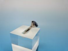 A white metal ring marked 18ct & platinum set with a synthetic sapphire of approximately 1.