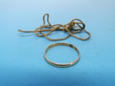 A yellow metal wedding band and a yellow metal chain