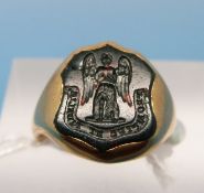 An 18ct gold signet ring set with a bloodstone seal with Latin script  below an angel (size J,