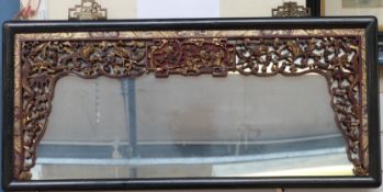 A Chinese mirror with fretwork border and hand decorated surround