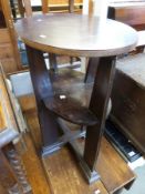An Arts and Crafts Glasgow School oak table, the oval top above an oval shelf,