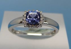 An 18ct white gold ring set with a topaz surrounded by diamonds (size P)