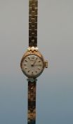 A boxed 9ct gold cased Garrard ladies' wristwatch on a 9ct gold strap,