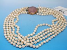 A five strand pearl necklace with a 15ct gold clasp set with a large rose quartz stone
