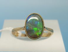 A yellow metal ring set with an oval fire opal (size L)