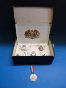 A cased George V commemorative miniature tea service together with a commemorative medal