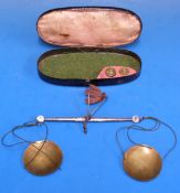 A cased set of steel and brass travelling beam scales,