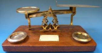A set of brass parcel scales with ivorine plaque and 1lb weights to the oak base,