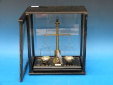 A glass cased set of diamond beam scales with weights