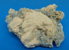 A geological sample formed of clusters of grey crystal with lighter surface to some parts,