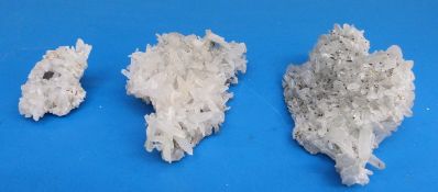 Three geological samples formed of snow coloured partially translucent crystals, two medium sized,