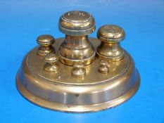 A brass pan of weights, on circular base,