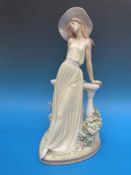 Two Lladro figures comprising a lady wearing a hat and leaning on a balustrade and a dancer