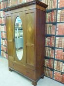An Edwardian style wardrobe with inlaid decoration and single drawer to base and glass mirror to
