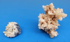 Two geological samples formed of amber and snow coloured crystals in coral-like formation,