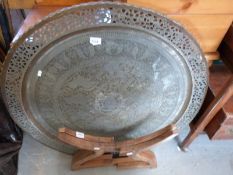 A large Eastern style pieced brass table on wooden base (88cm diameter)