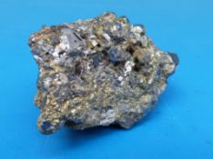 A geological sample of a dark grey quartz with bright stone and scattered fools gold,