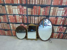 Two mahogany oval framed mirrors one with carved decoration together with a gilt framed mirror