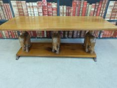 A hardwood coffee table with figural elephant supports (length 122cm) and figural elephant wine