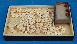 Two carved bone necklaces and three seed pods with miniscule figures inside
