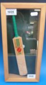 A miniature cricket bat signed by David Gower in a glazed pine case