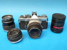 An Olympus OM - 2N camera together with two further lenses,